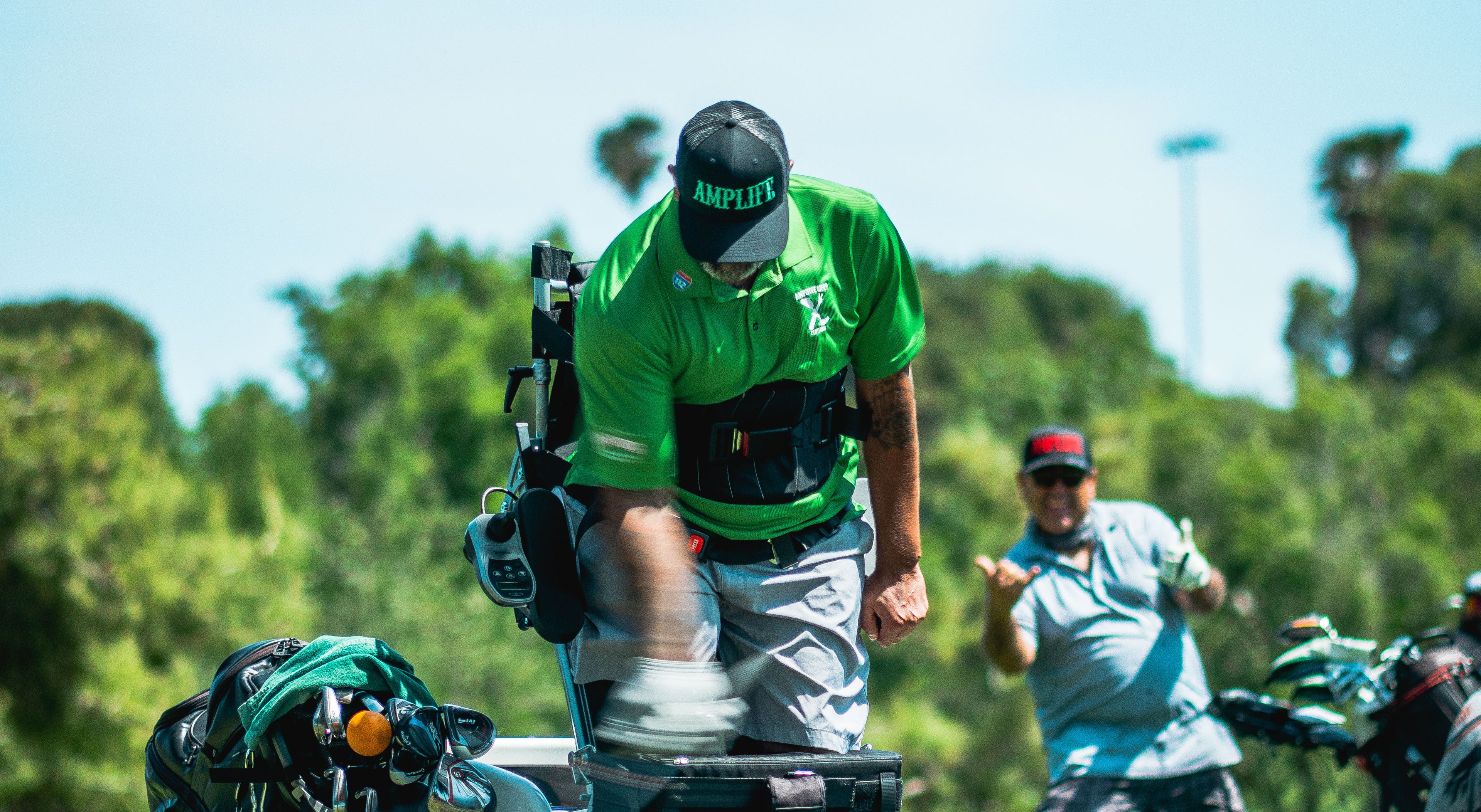 Amplife® Foundation & Amplife® Founder Abdul Nevarez hitting golf shot while being a photobombed by an Amplife® Supporter