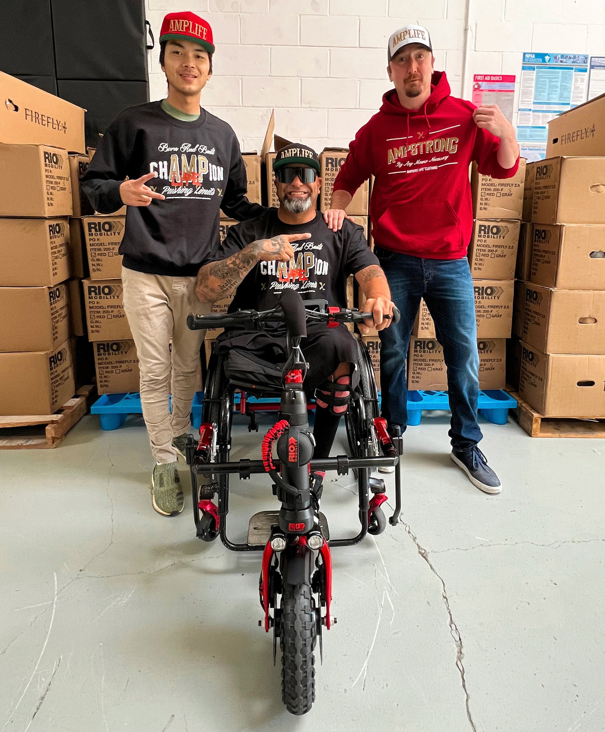 Potrait of Amplife® Foundation & Amplife® Founder Abdul Nevarez on his Rio Mobility Firefly 2.5 Electric Scooter Wheelchair Attachment at Rio Mobility's HQ with the CEO and technician
