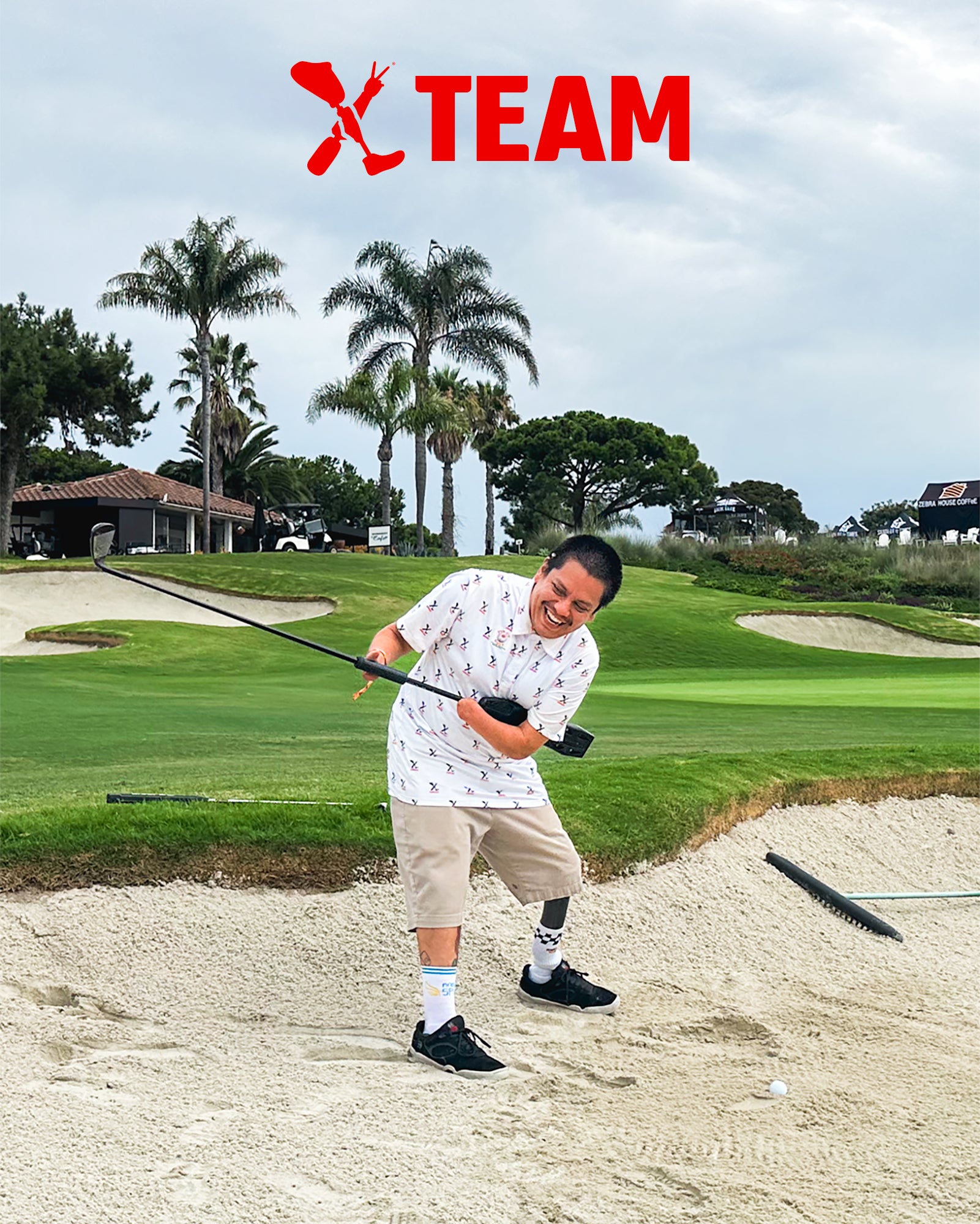 Team Amplife® Ambassador Oscar Loreto, Jr. golfing in a sand trap while laughing during his backswing.