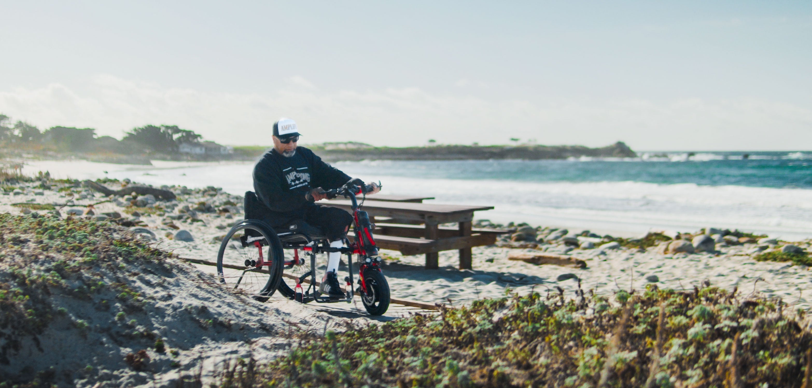 Amplife® Foundation & Amplife® Founder Abdul Nevarez riding his Rio Mobility Firefly 2.5 Electric Scooter Wheelchair Attachment at Pebble Beach