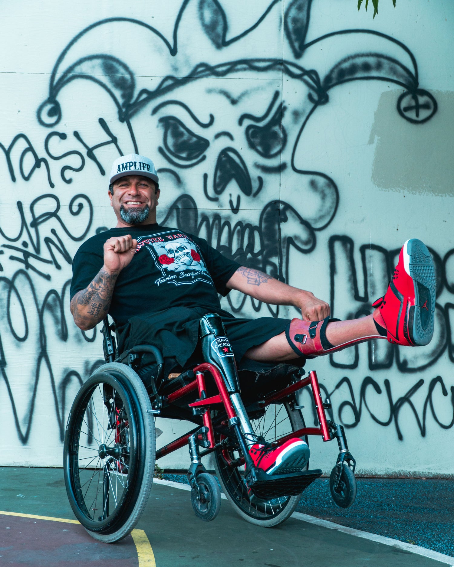 Portrait of Amplife® Foundation & Amplife® Founder Abdul Nevarez wheeling in his wheelchair and holding his fist in a wide open position