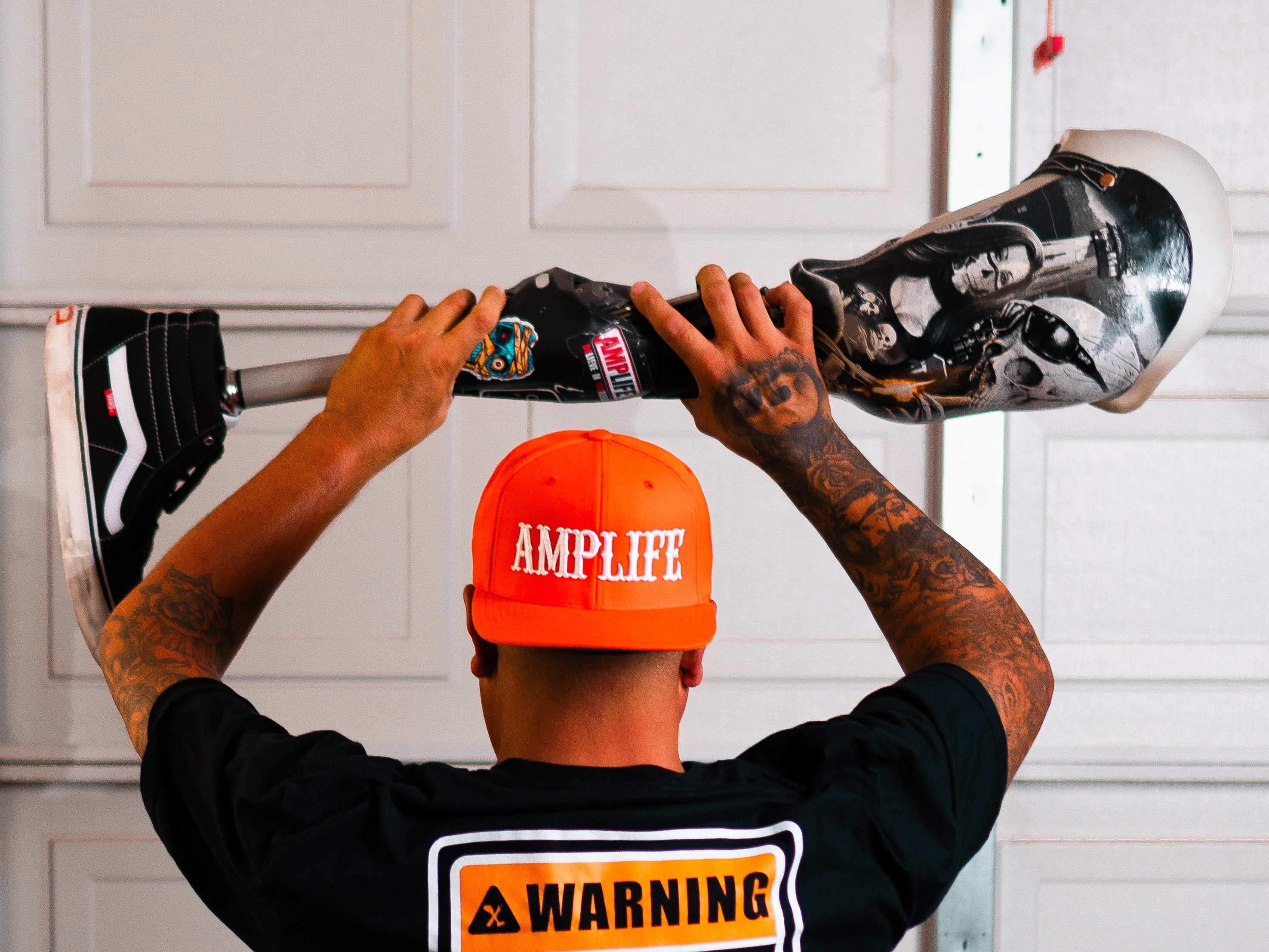 Photo behind Amplife® Foundation & Amplife® Founder Abdul Nevarez as he holds his prosthetic leg above his head
